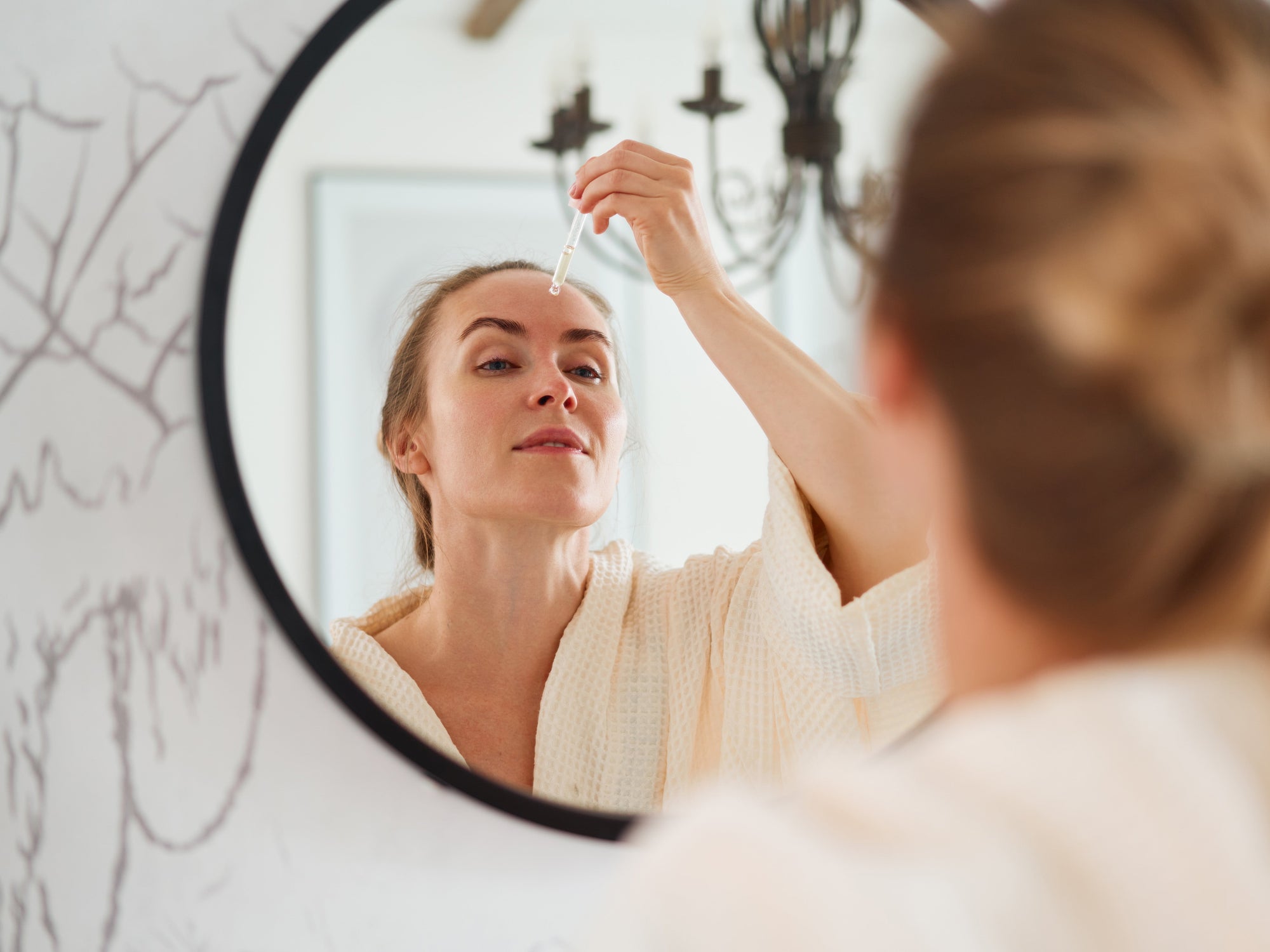 woman applying retinol on her face