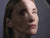 model with glowing skin looking at the camera on a grey background
